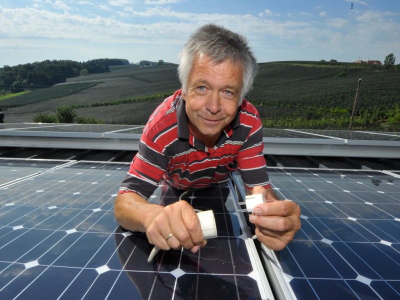 Josef Wilhelm inmitten seiner Photovoltaik-Anlage am Dach seines Biomasse-Heizwerks.